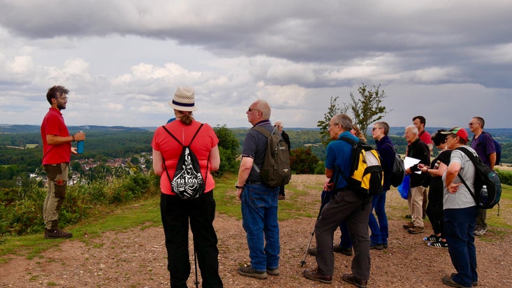 Ranger talking to walkers with view over Kinver